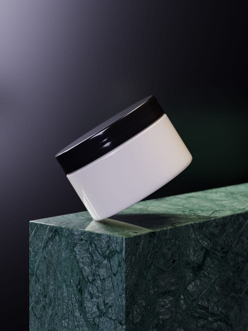A sleek cosmetic jar standing on a marble surface